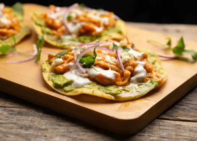 Tostada de maíz con pavo en escabeche, guacamole y cebollitas encurtidas